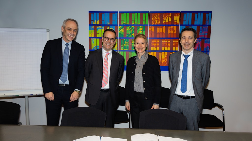 La directrice de l'OFT Christa Hostettler et le sous-directeur de l'OFT Martin von Känel se tiennent devant un mur, en ligne avec Paolo Caroni, président du conseil d'administration FART, et Claudio Blotti, directeur FART. Devant eux, sur la table, se trouve le dossier avec le contrat de prestations