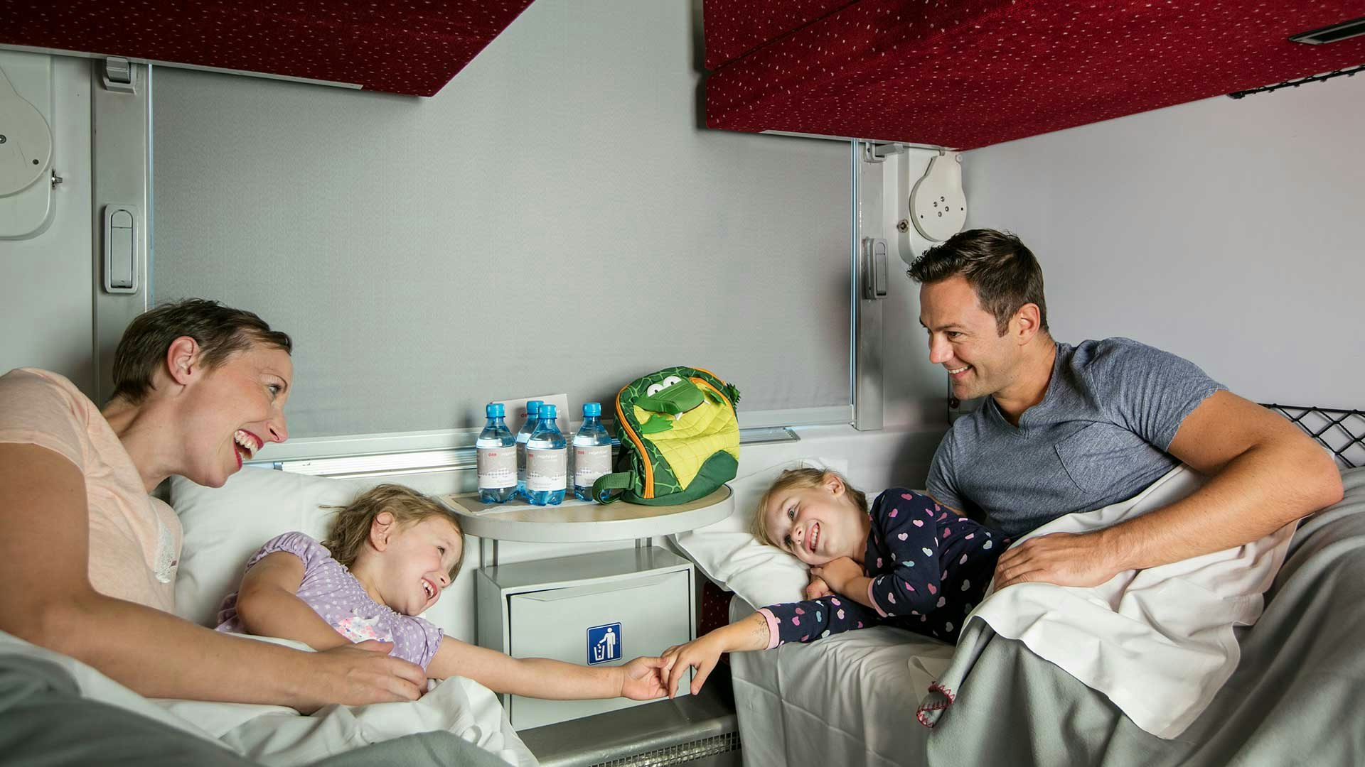 Familie mit zwei kleinen Kindern im Nachtzug.