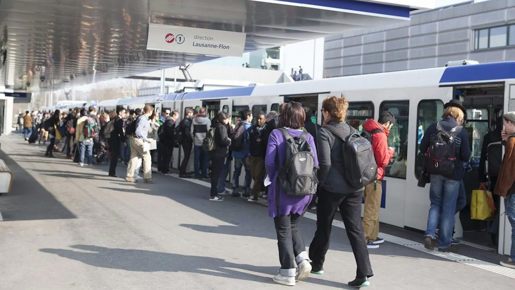 Personen auf dem Perron steigen in die M1 Richtung Lausanne-Flon ein.