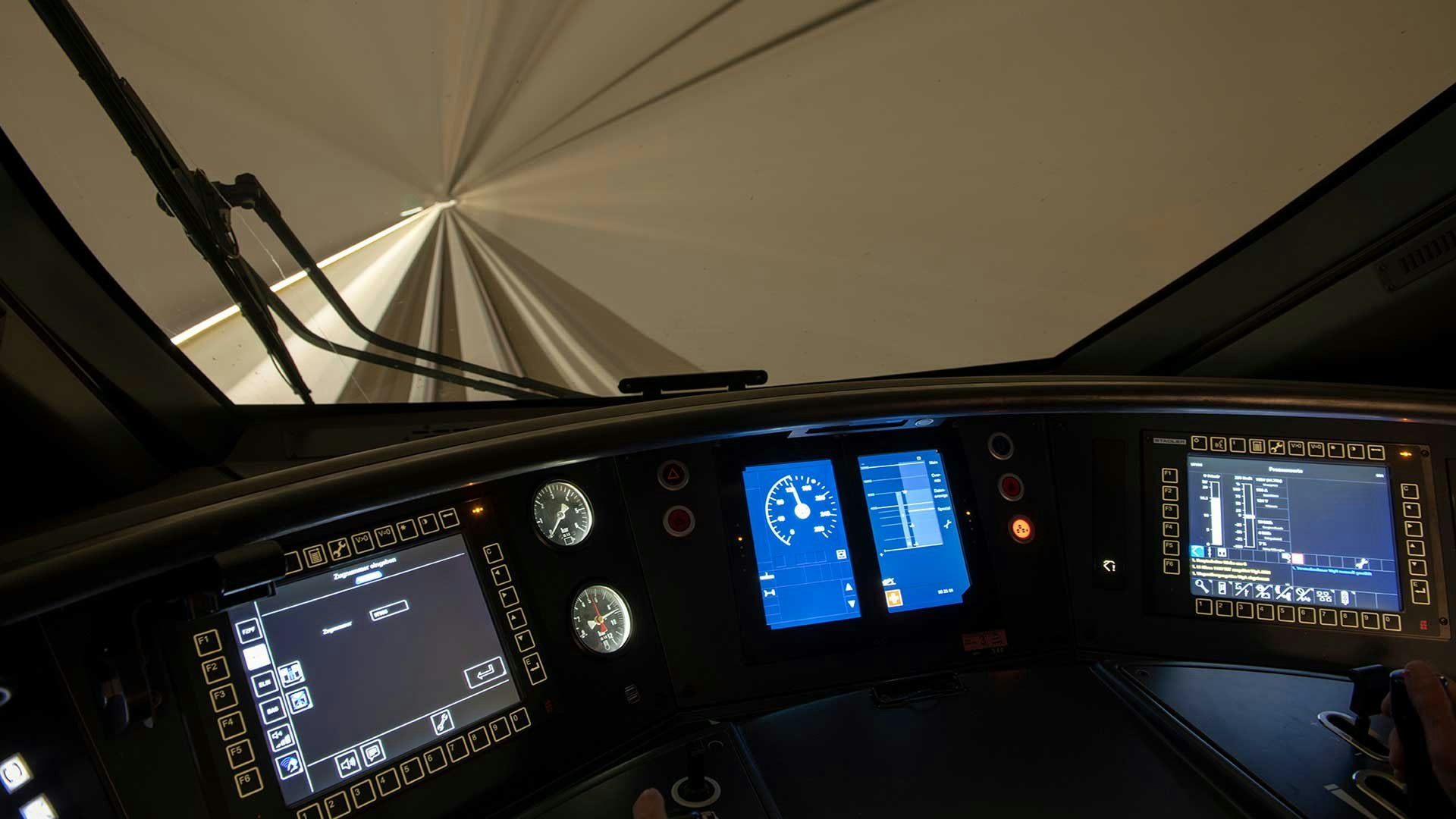 Führerstand eines Giruno im Ceneri-Basistunnel mit diversen Bildschirmen.