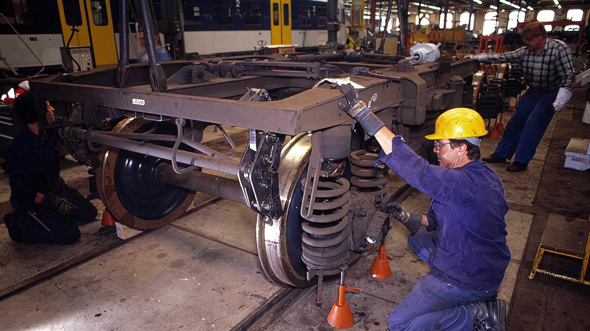 Un spécialiste travaille sur le châssis d'un wagon de marchandises.