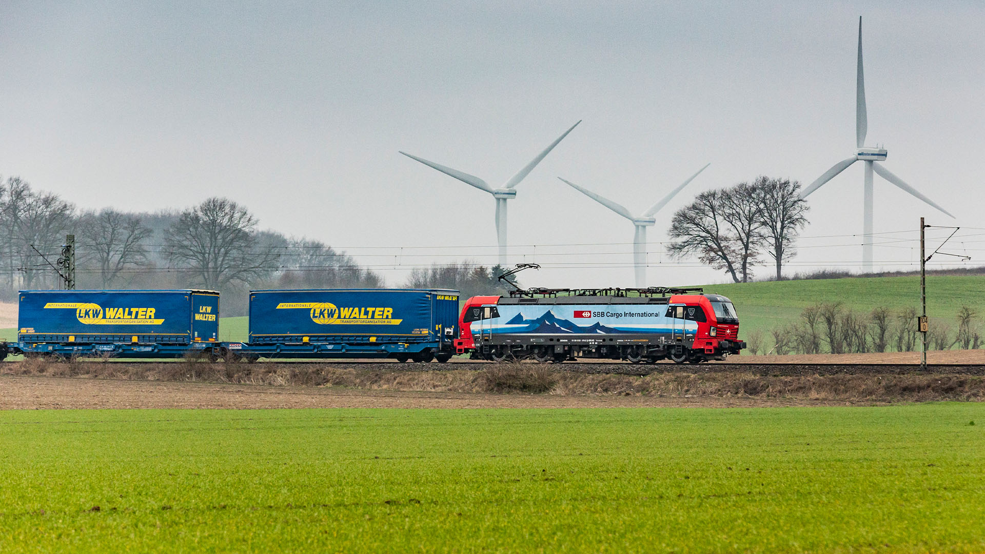 Un train de marchandises CFF Cargo avec plusieurs remorques sur les rails.