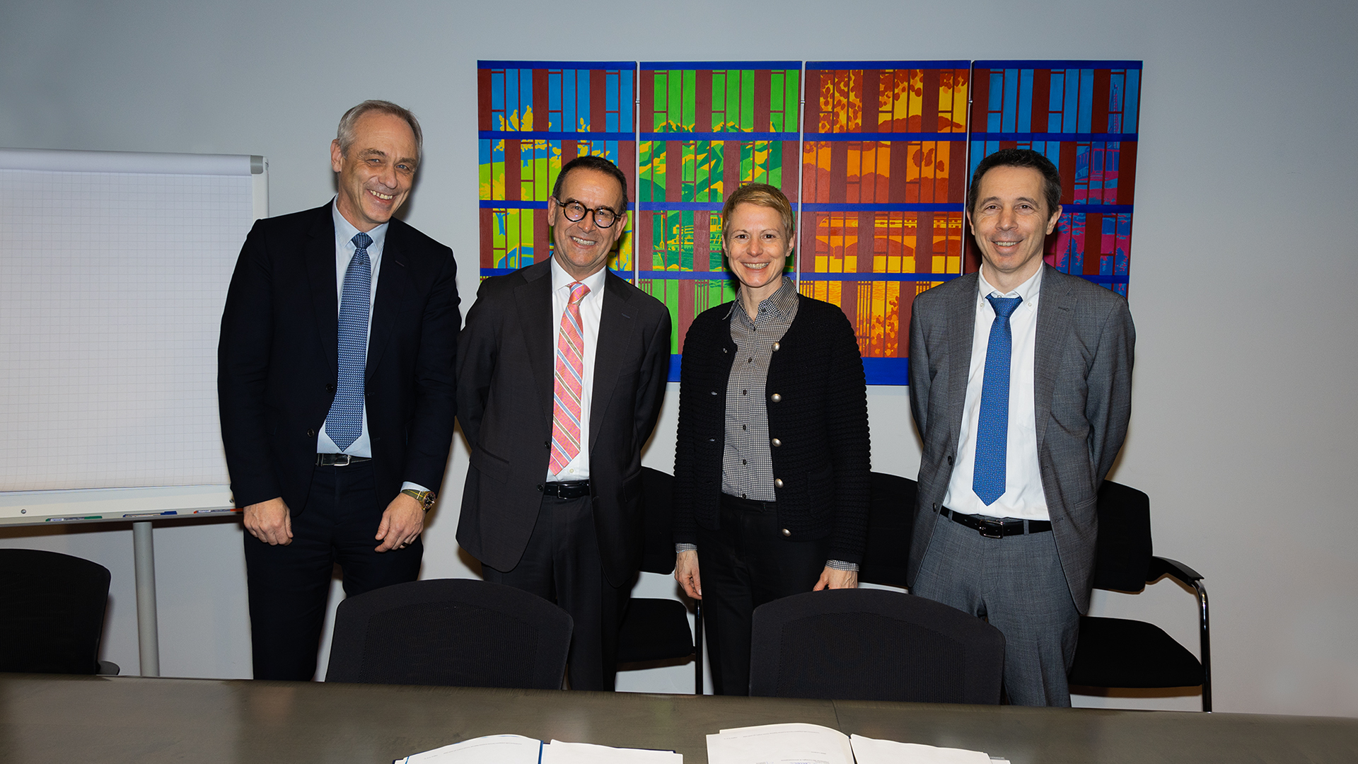 La directrice de l'OFT Christa Hostettler et le sous-directeur de l'OFT Martin von Känel se tiennent devant un mur, en ligne avec Paolo Caroni, président du conseil d'administration FART, et Claudio Blotti, directeur FART. Devant eux, sur la table, se trouve le dossier avec le contrat de prestations